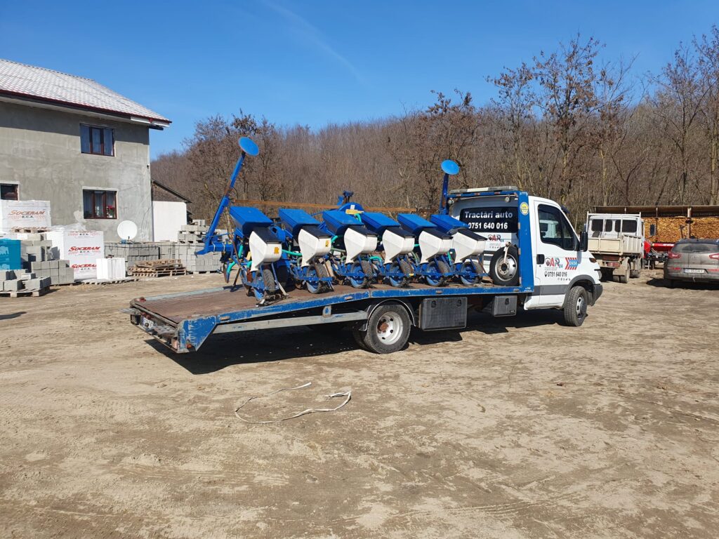 Utilaj agricol incarcat corect pe platforma auto Traian TKD, pregatit pentru transport in siguranta.