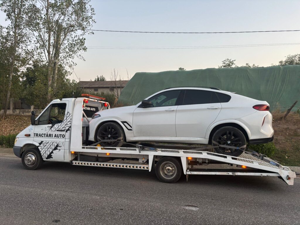Platformă de tractări Traian TKD transportând un BMW X6 alb, un exemplu de serviciu profesional pentru cine caută să afle cat costa o tractare auto in iasi.